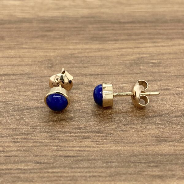 Gold earrings with blue gemstone studs.