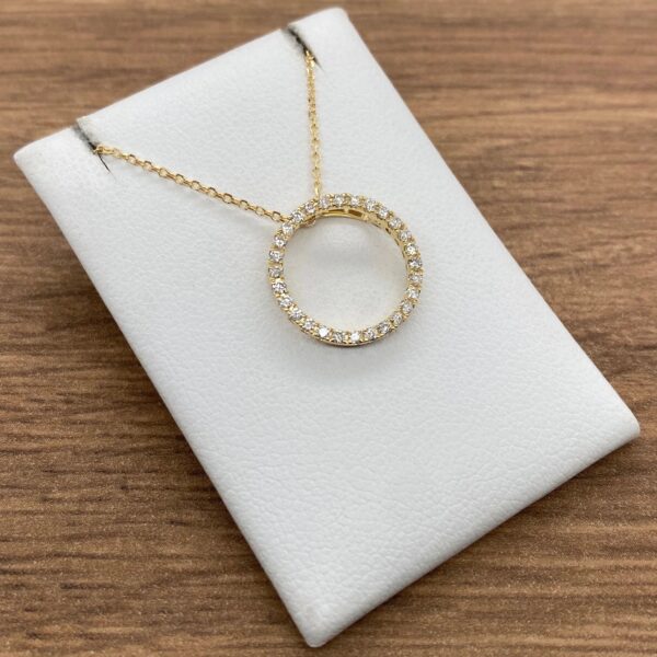 Gold necklace with a diamond circle pendant.