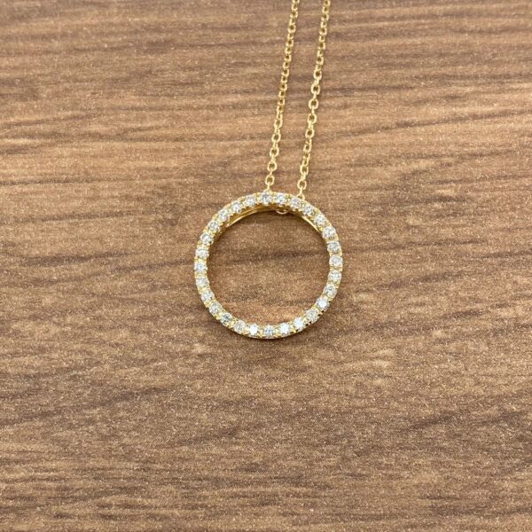 Gold necklace with round diamond pendant.