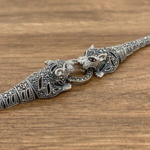 A silver bracelet with two tigers on it.