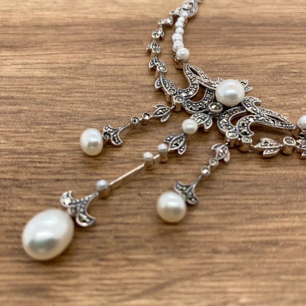 Silver necklace with pearl and marcasite details.