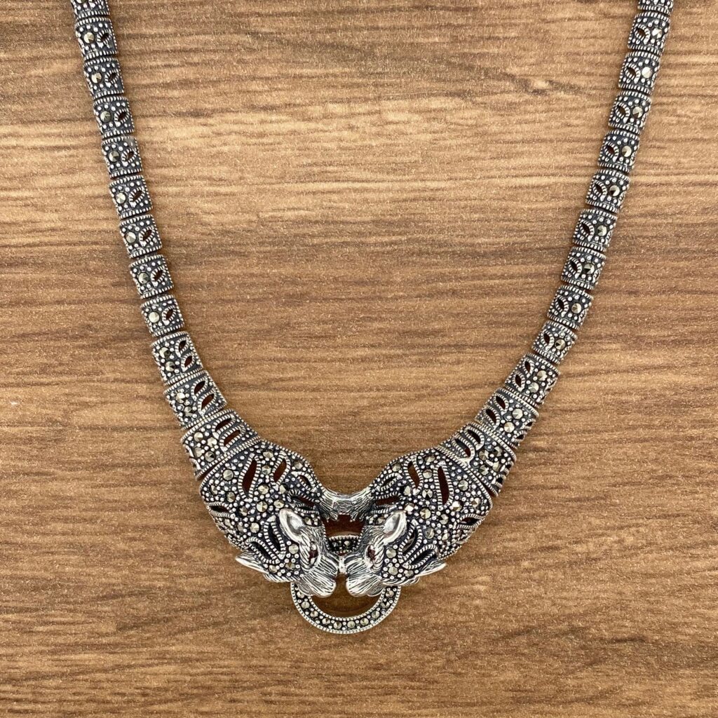 Silver necklace with tiger head pendants.