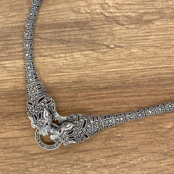 Silver snake necklace with ornate details.