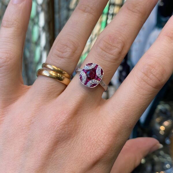 Hand wearing a ruby and diamond ring.