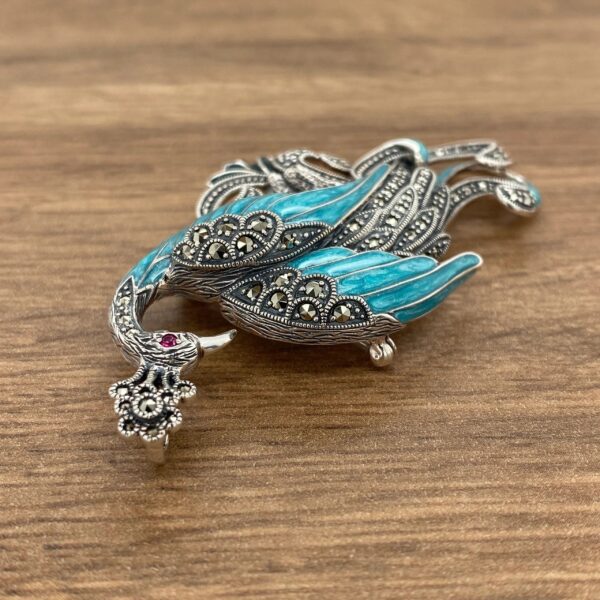 Silver peacock brooch with blue enamel.