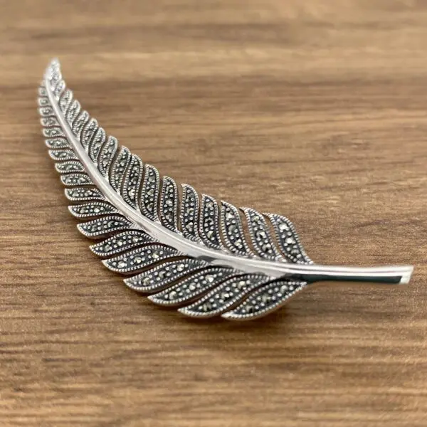 Silver fern brooch with marcasite stones.