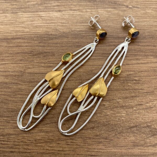 Silver and gold leaf earrings with green stones.