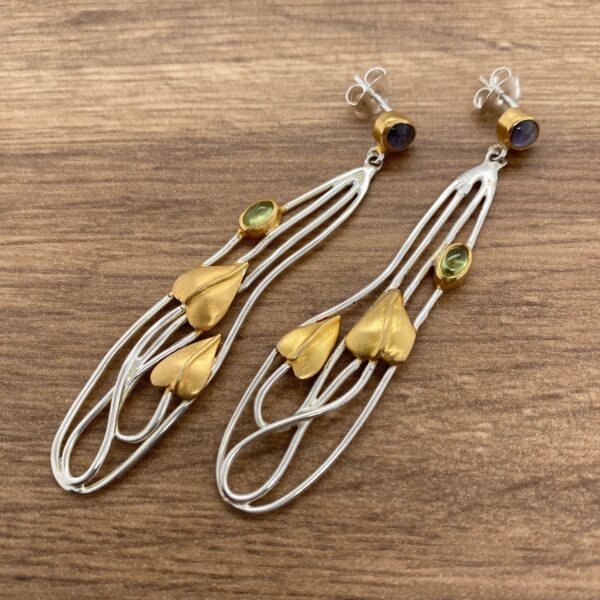 Silver and gold earrings with green stones.