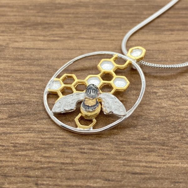 Silver bee necklace with honeycomb pendant.