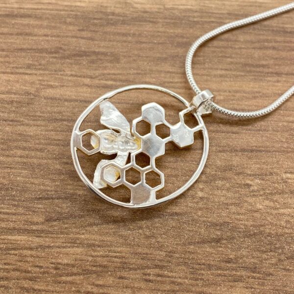 Silver bee and honeycomb necklace pendant.