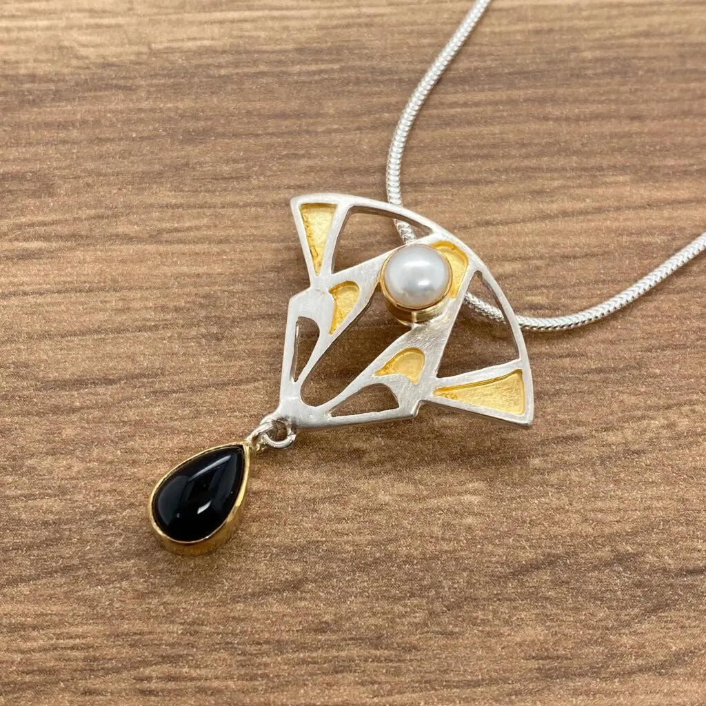 Silver and gold necklace with pearl and onyx.