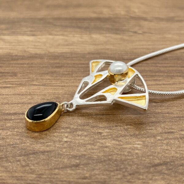 Gold and silver necklace with black and white stones.