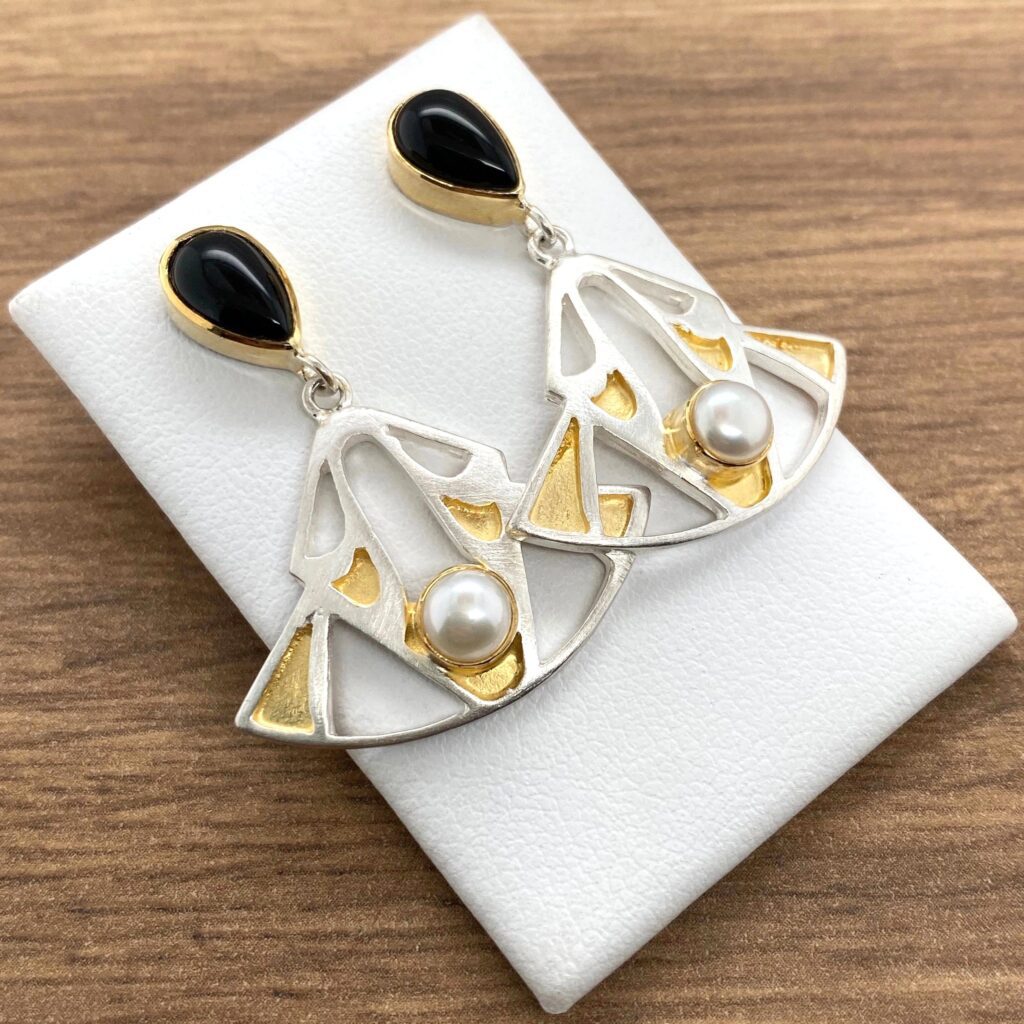 Silver earrings with pearls and black stones.