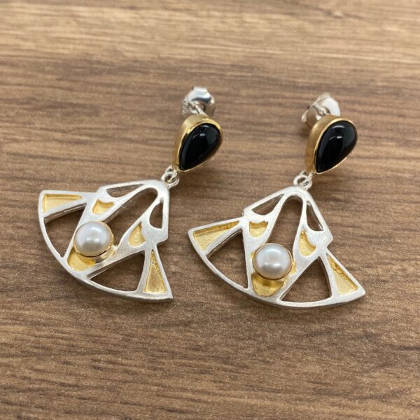 Gold and silver earrings with black and white stones.