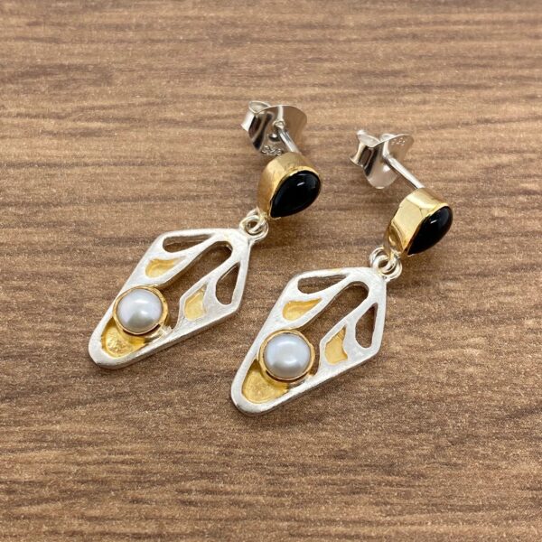 Gold and silver earrings with black and white stones.