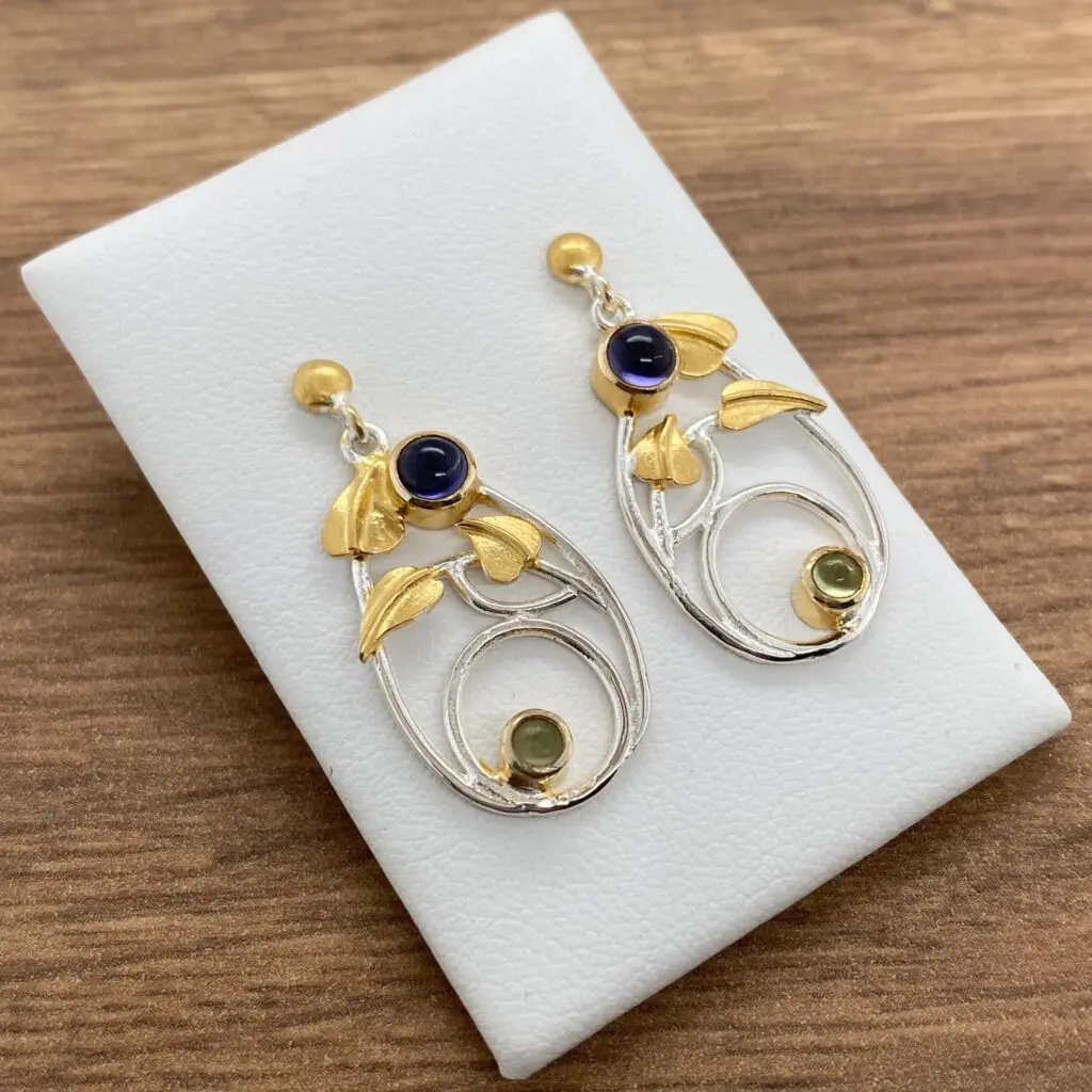 Silver and gold earrings with gemstones.