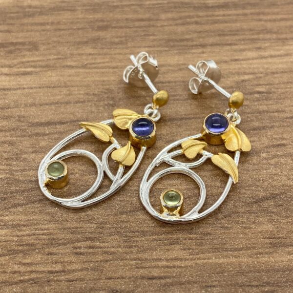 Silver and gold leaf earrings with gemstones.