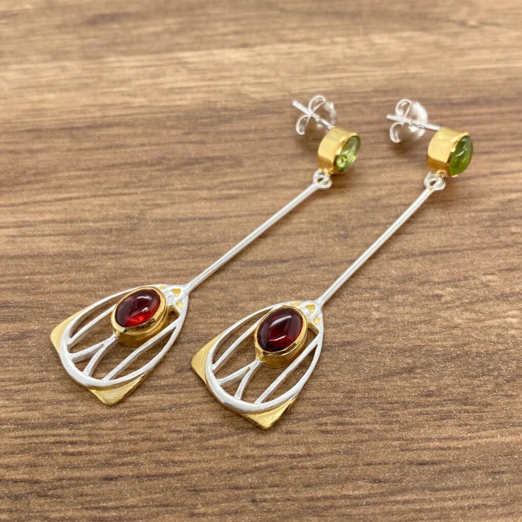 Gold and silver earrings with red and green stones.