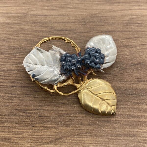 Gold and silver leaf brooch with berries.