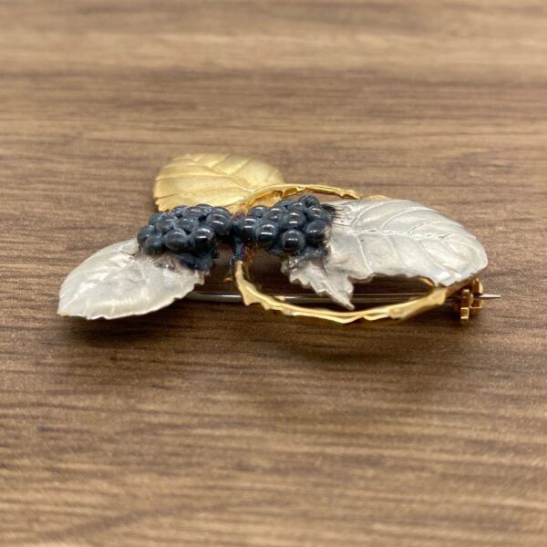 Gold and silver leaf brooch with berries.