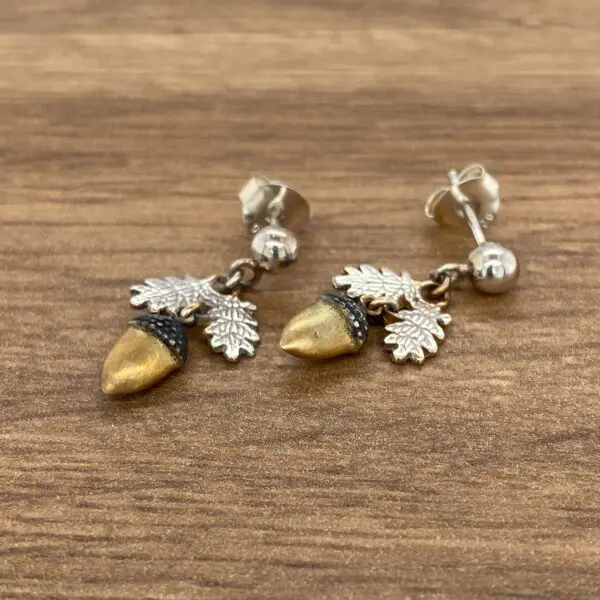 Gold acorn earrings with leaf accents.