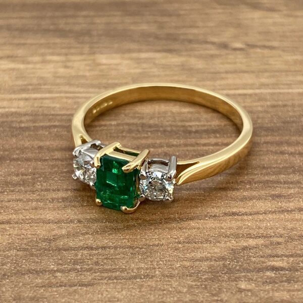 Gold ring with emerald and diamond stones.