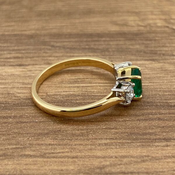 Gold ring with emerald and diamonds.