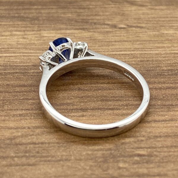 Silver ring with a blue sapphire and diamonds.