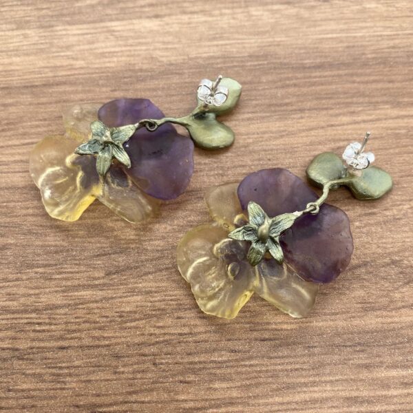 Pair of purple and yellow flower earrings.