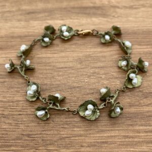 A bracelet with green leaves and pearls.