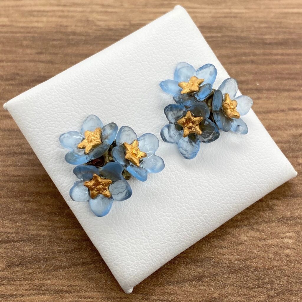 Blue flower stud earrings with gold centers.