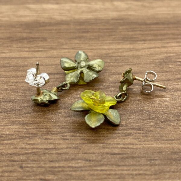 A pair of green and yellow flower earrings.