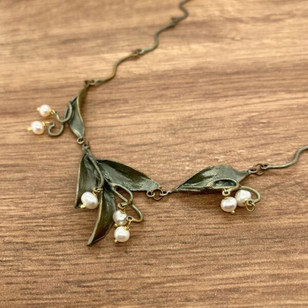 Bronze leaf necklace with pearl accents.