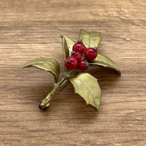 Gold holly sprig with red berries.