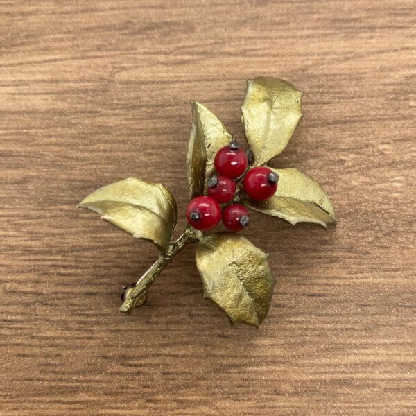 Gold holly sprig with red berries.