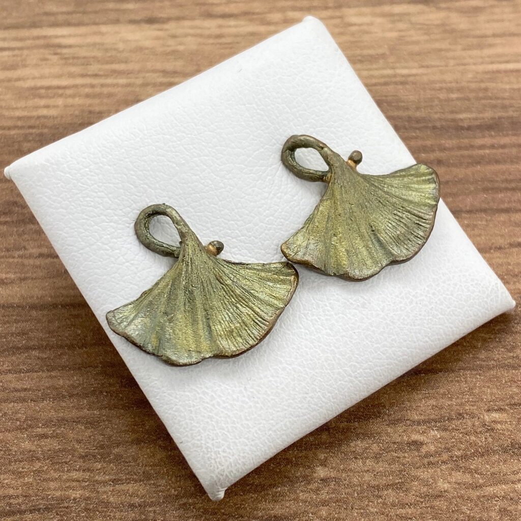 Pair of ginkgo leaf earrings on display.