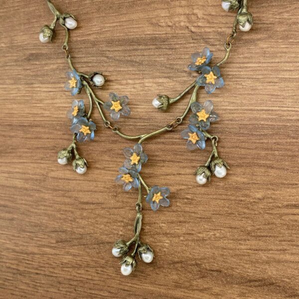 Floral necklace with blue flowers and pearls.