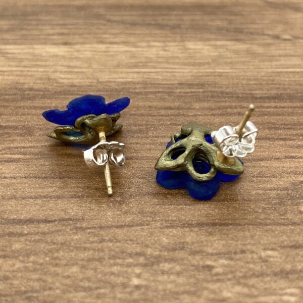 Blue flower stud earrings with gold accents.