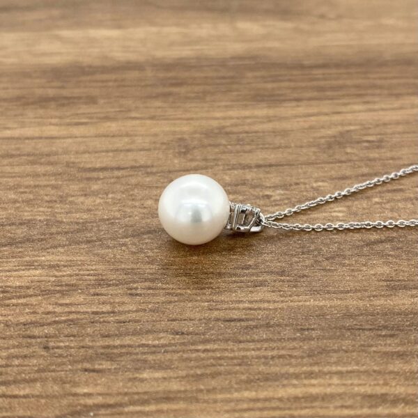 White pearl pendant on silver chain.