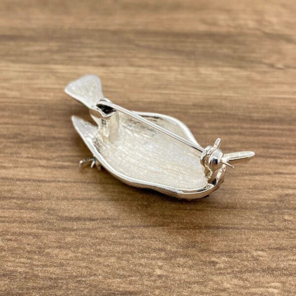 Silver bird brooch with pin on back.