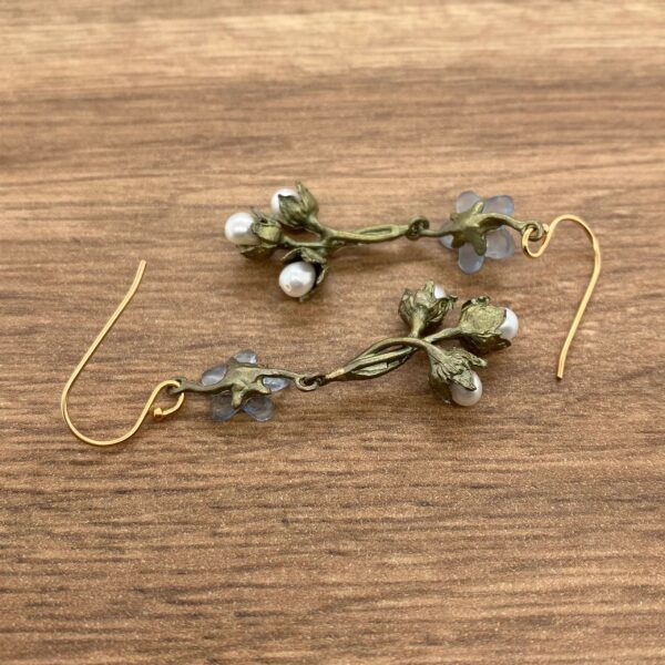 Gold floral earrings with pearls and blue stones.