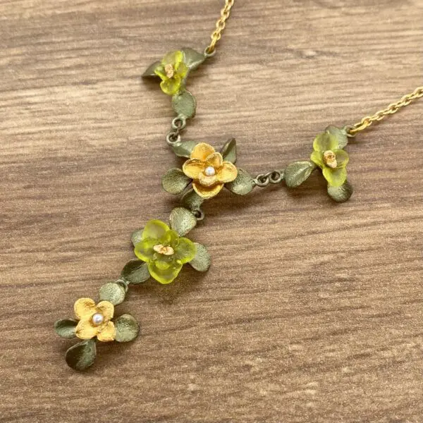 Gold flower necklace with green leaves.