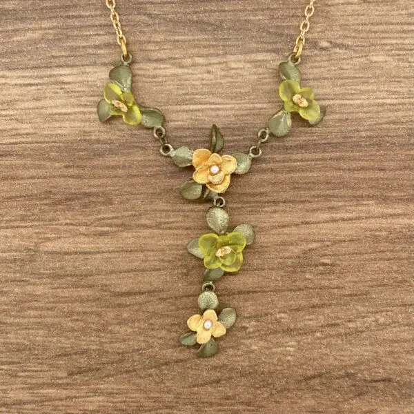 Gold floral necklace with green leaves.