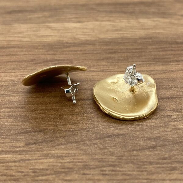 Gold earrings with irregular shape.