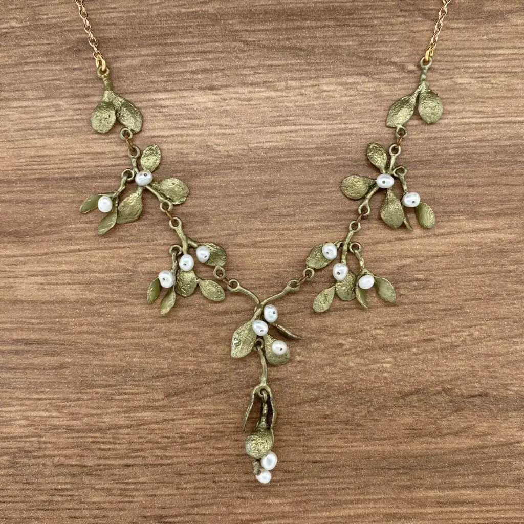 Gold mistletoe necklace with white pearls.