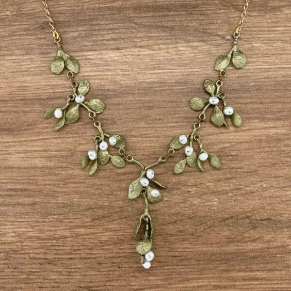 Gold mistletoe necklace with white pearls.