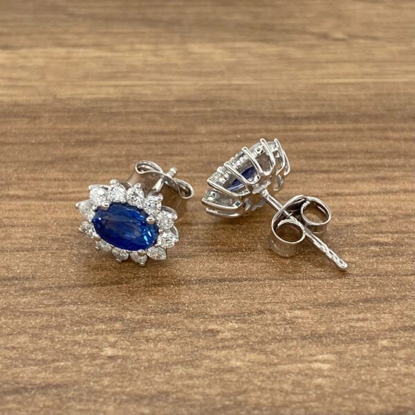 Sapphire and diamond earrings on wood.