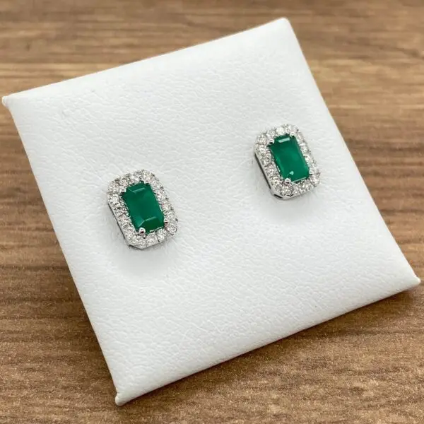 Emerald and diamond halo earrings.