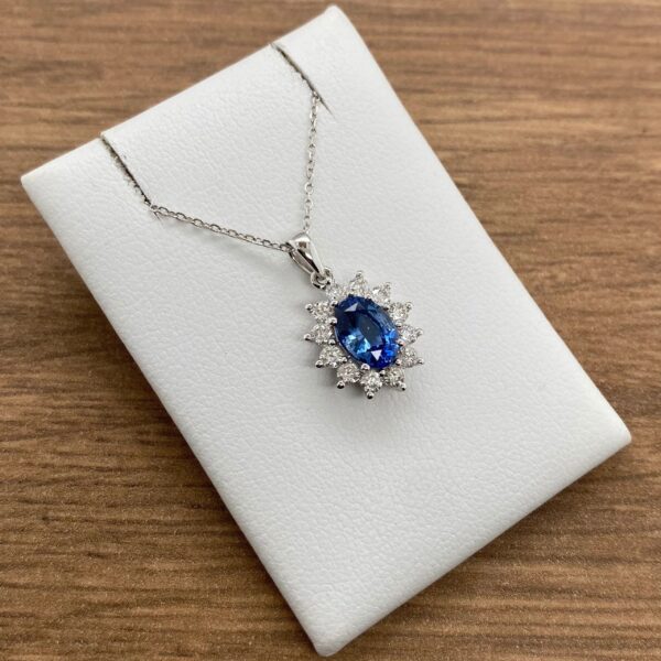 Oval sapphire pendant with diamond halo.