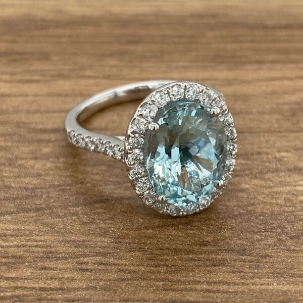 Diamond halo ring with aquamarine center stone.